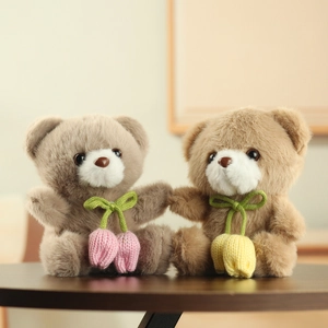 Cute teddy bear plush charms in brown and grey with knitted tulip pendants on a wood table