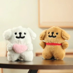 Close-up of cute plush dog keychains with heart and ribbon details on a wooden surface
