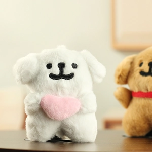 Close-up of white plush puppy toy holding a pink heart with embroidered smile detail