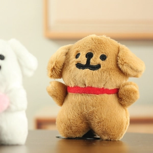 Close-up of soft brown plush puppy with red ribbon and cute embroidered facial features