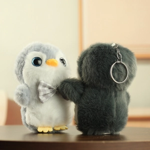 Vue détaillée de porte-clés pingouin en peluche douce avec nœuds papillon mignons