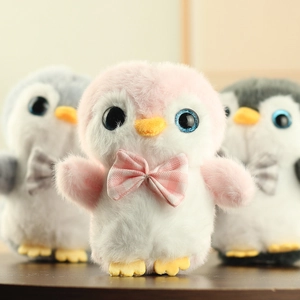Détail d'un porte-clés manchot en peluche douce avec yeux scintillants et nœud écossais