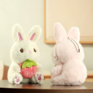 Détail de breloques lapins en peluche avec accessoire fraise et texture douce