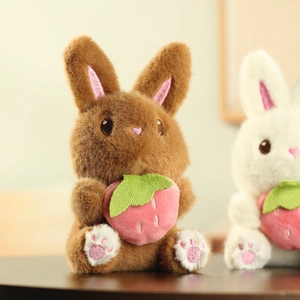 Vue détaillée d'un lapin en peluche doux tenant une fraise rose avec une texture de fourrure
