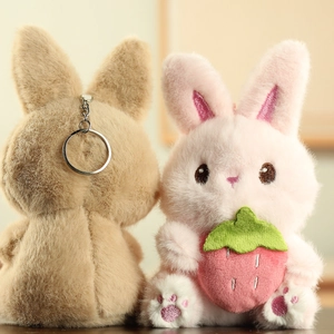 Détail de porte-clés lapin en peluche avec crochet métallique et accessoire fraise