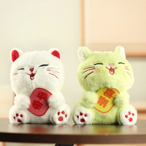 Dettaglio di portachiavi a forma di gatto in peluche con ricami e ciondoli portafortuna