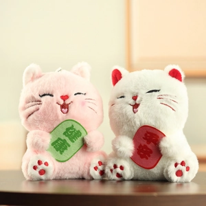 Dettaglio di portachiavi a forma di gatto della fortuna in peluche con ricami di salute e pace
