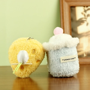 Lindos llaveros de peluche con forma de queso y pastel sobre un escritorio de madera natural