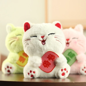 Dettaglio dei ciondoli in peluche a forma di gatto della fortuna con scritte benauguranti