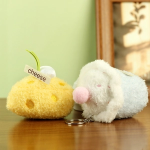 Detalle del set de colgante de peluche de queso y animal con llavero sobre madera