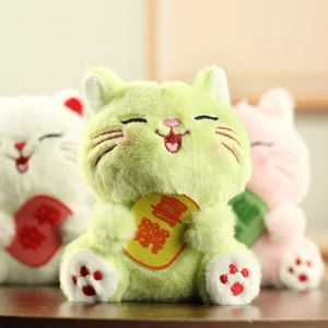 Primo piano di gatti di peluche colorati con segni portafortuna ricamati per la gioia