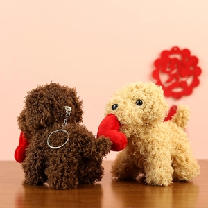 Detail of plush teddy dog keychains in brown and beige with a red velvet heart decoration