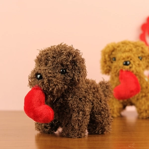 Close-up of a brown plush teddy dog toy holding a red heart on a wooden table