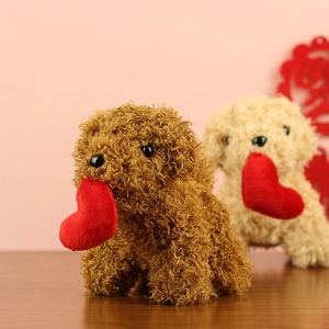 Close-up of soft plush teddy dog toys in brown and cream colors with red hearts