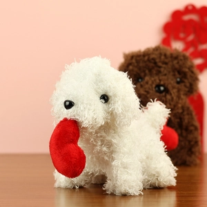 Detail of plush teddy dogs with soft curly fur holding a red heart for Valentine's Day