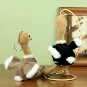 Porte-clés autruche en peluche marron et noir sur une table en bois rustique
