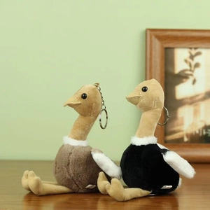 Détail de porte-clés autruche en peluche avec fourrure douce et anneau métal sur bois