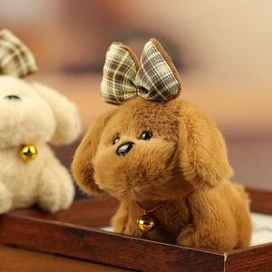 Close-up of plush puppy pendant with a plaid bow and golden bell on a wooden tray