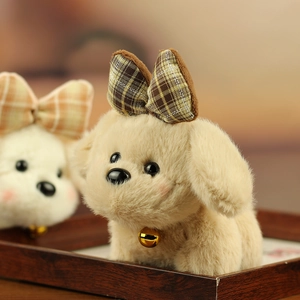 Close-up of plush puppy pendants with checkered bows and bells in soft brown and white