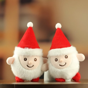 Détail de deux peluches Père Noël avec bonnets rouges et barbes blanches douces