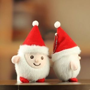 Gros plan de mignonnes figurines de Noël en peluche avec chapeaux rouges sur bois