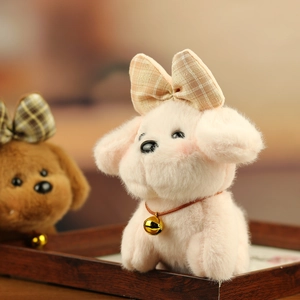 Close-up of plush puppy charm with pink fur and a brown checkered bow and small bell