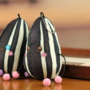 Detail van schattige pluche zonnebloempit sleutelhangers met gezichtjes op houten tafel