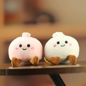 Détail de breloques brioches en peluche rose et blanc avec broderies de visage mignon