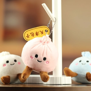 Détail de porte-clés en peluche baozi rose, blanc et bleu avec étiquettes Tianjin Bun