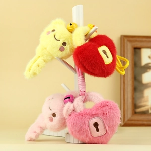 Cartoon plush keychain set with heart and bear shapes on a white decorative stand