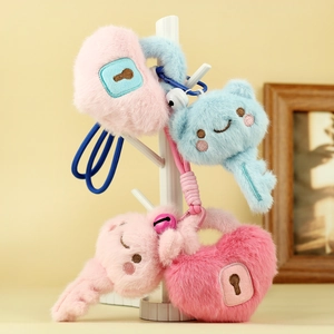Detail of plush lock and key keychains with cute embroidery in pink and blue colors
