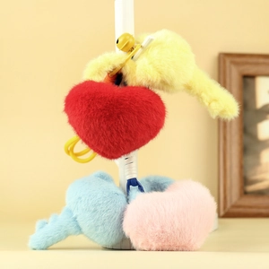 Detail showing plush heart keychains in red, yellow, blue and pink with golden bells