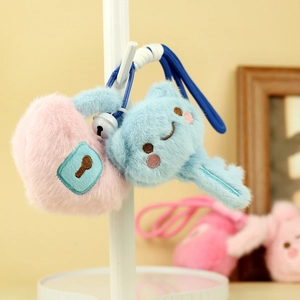 Detail of plush heart lock and key keychain with fine embroidery and small white bell
