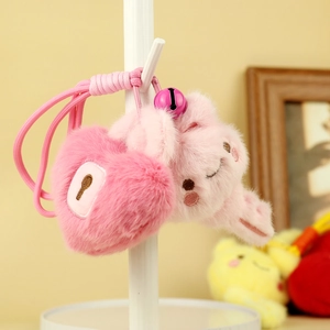 Detailed view of pink plush heart lock and animal keychain with braided rope and bell