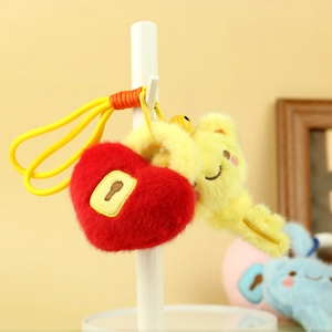 Close-up of cute red heart and yellow key plush pendants with smiley faces and metal clips