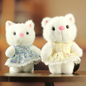 Gros plan de deux chatons en peluche portant des robes en dentelle fleurie bleue et jaune