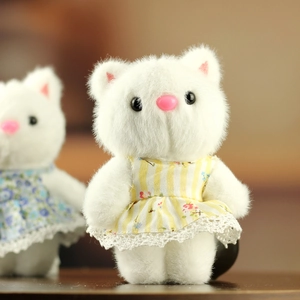 Vue détaillée de la peluche chat blanc avec robe à fleurs jaune et finitions en dentelle