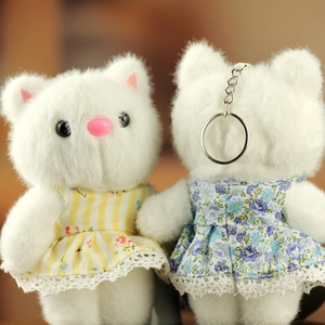 Détail de porte-clés chat en peluche avec robe en dentelle et texture douce blanche