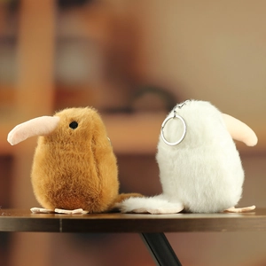 Detailed view of fluffy brown and white kiwi bird plush keychains on a wooden surface