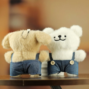 Gros plan d'adorables peluches chiens en salopette bleue avec fourrure douce et chaînes