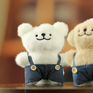 Détails macro de peluches chien et ours en salopette en jean avec coutures fines