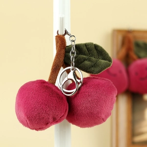 Detailansicht eines rosa Plüsch-Kirsch-Schlüsselanhängers mit Blättern und Metallring