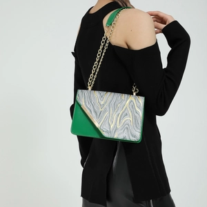 Borsa a tracolla geometrica verde smeraldo con catena dorata indossata da modella