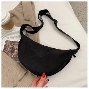 Close-up of black nylon half-moon crossbody bag with adjustable strap and zipper detail