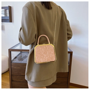 Detail of nude pink floral embossed handbag with gold chain strap and metal frame