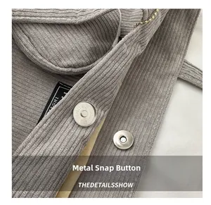 Detail shot of the secure metal magnetic closure on a gray corduroy tote bag