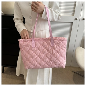 Detailed shot of pink quilted tote bag with diamond stitching and leather straps