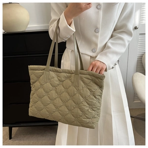Lifestyle shot of an olive green quilted tote bag with diamond stitching and large capacity