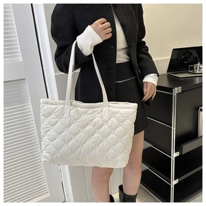 Detailed view of a white quilted tote bag with soft padded nylon and large capacity