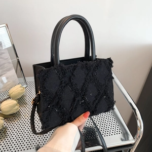 Large black quilted tote bag with fringe texture and dual handles for women